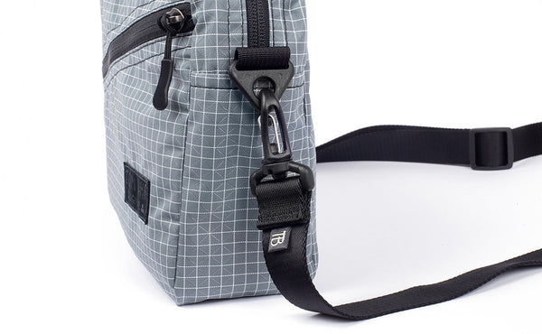 A close shot of the Packing Cube Shoulder Bag's d-ring strap attachment point with a 1" shoulder strap attached.